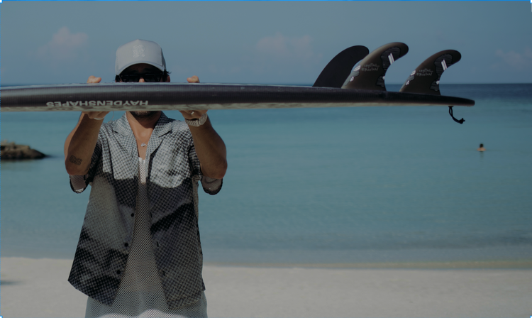 Person holds surfboard on beach.