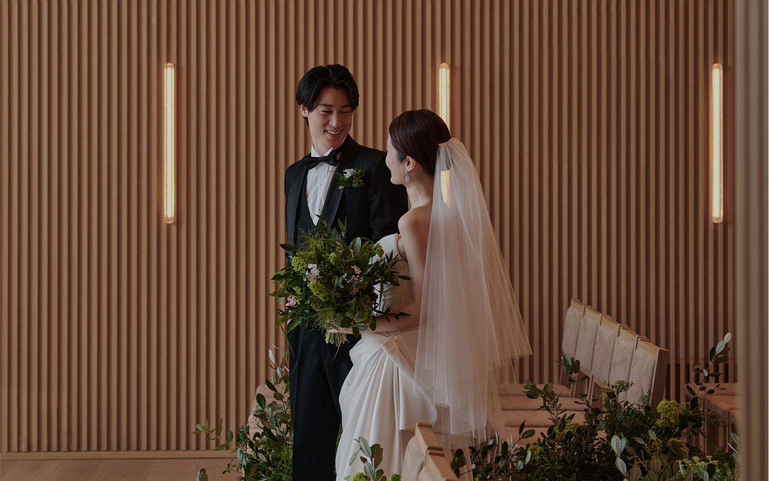 縦格子の壁を背に、幸せの笑みを浮かべる新郎新婦。