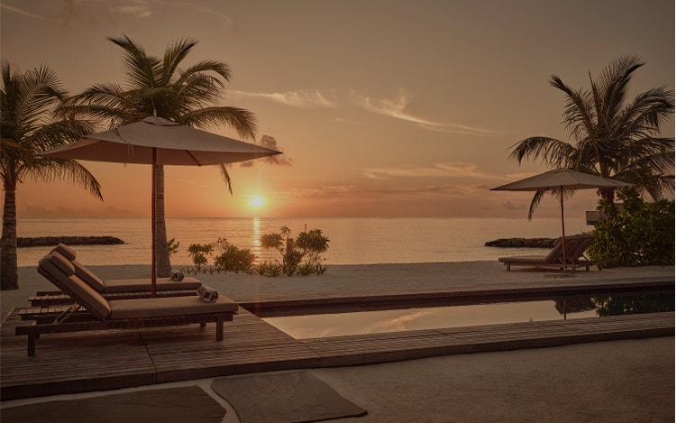 Sunset glows over beachfront pool deck.