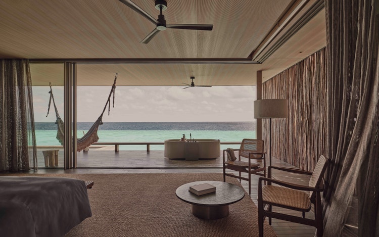 Oceanfront villa with hammock and chairs.