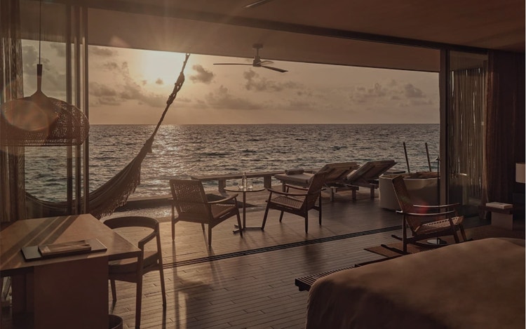 Sunset glows through open villa doors.