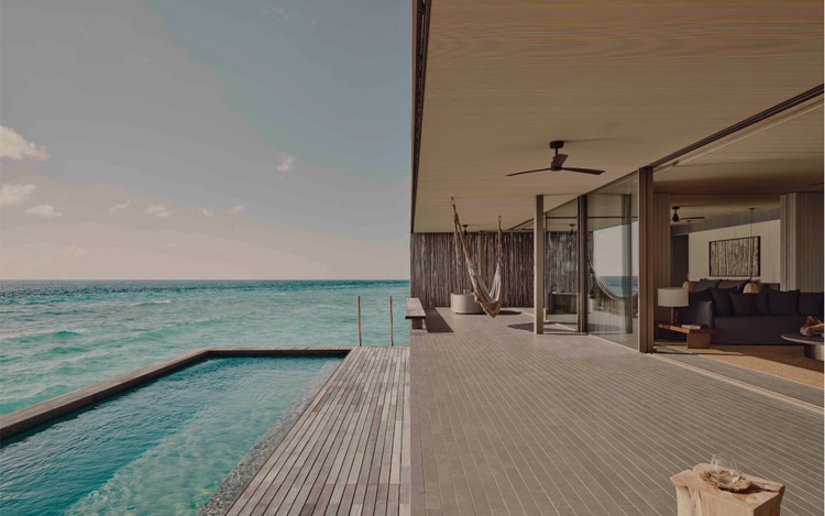 Deck and pool overlook turquoise ocean.
