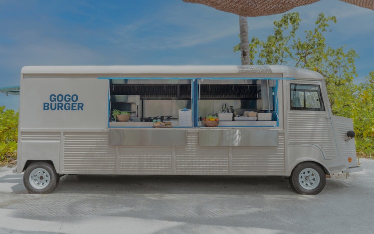 Retro-Burgertruck in tropischem Ambiente.