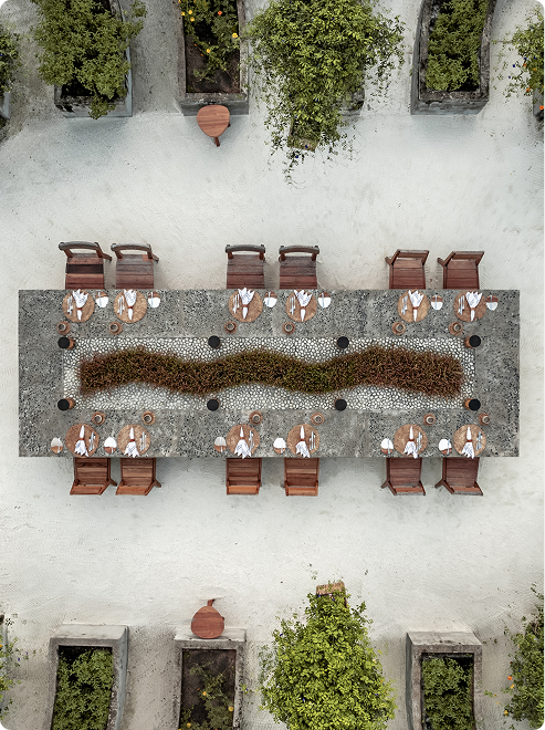 Langer Outdoor-Tisch mit Blattdeko in der Mitte.