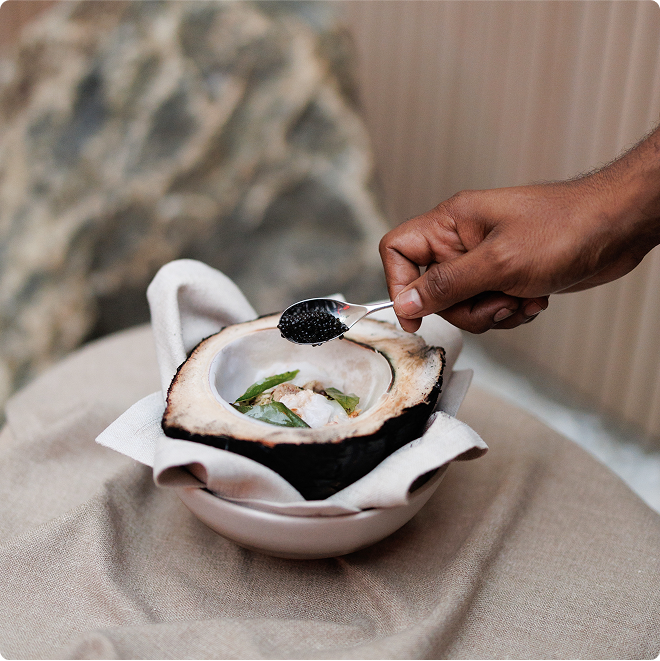 Coconut shell holds luxe seafood garnish.