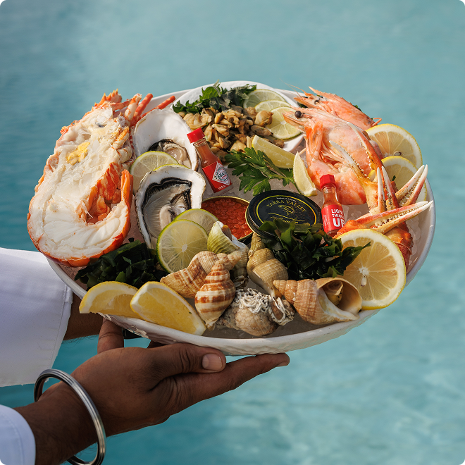 Assorted seafood platter above pool water.