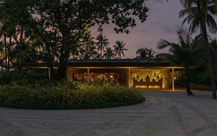 Modern restaurant nestled in tropical greenery.