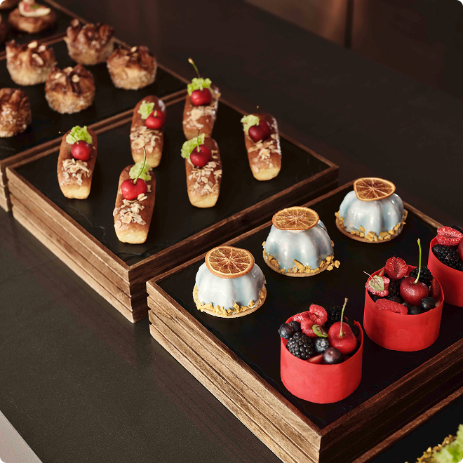 Assorted gourmet pastries on wooden trays.