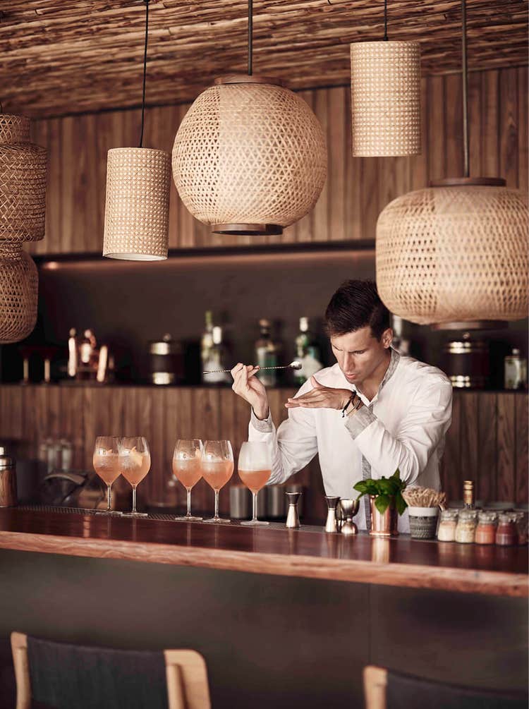 Bartender tastes cocktail in stylish bar.
