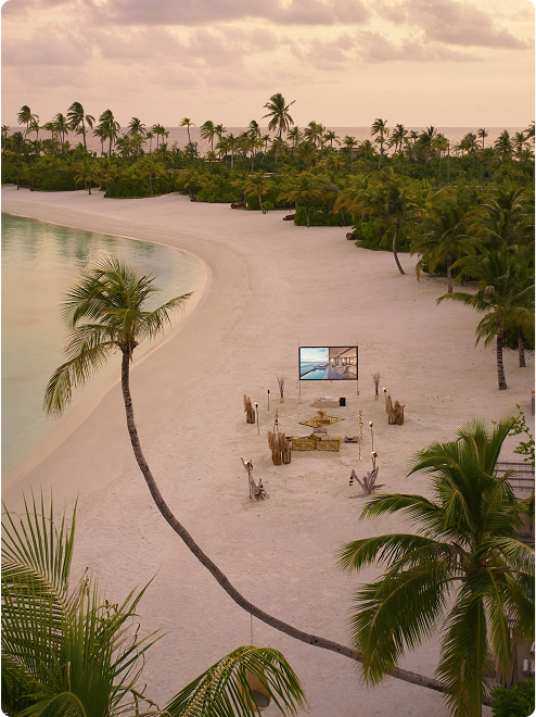 Cushioned seating faces screen at sunset.
