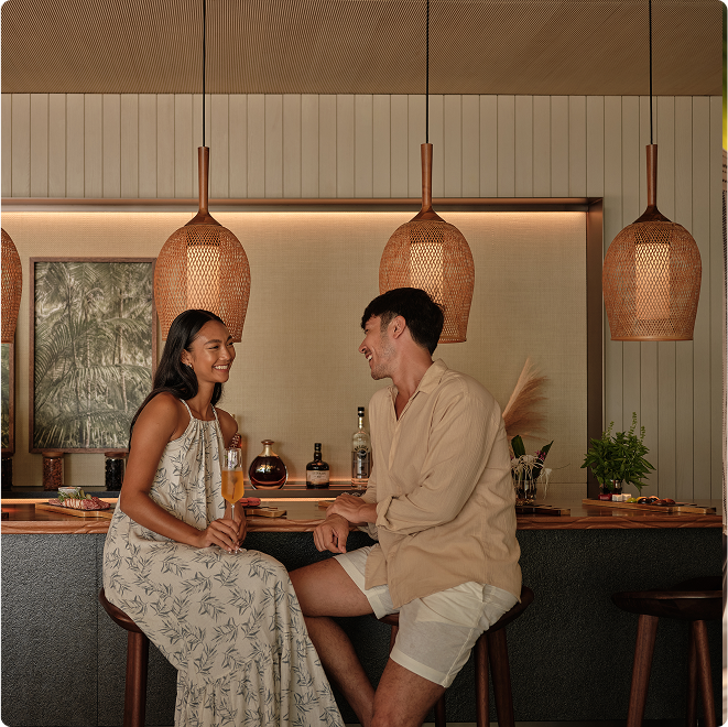 Guests chat at warmly lit bar.