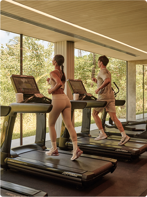 Guests run on treadmills with greenery view.