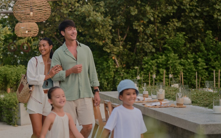 Family gathering in lush tropical setting.
