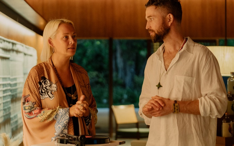 Two guests converse in warm setting.