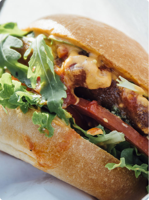フレッシュな野菜をトッピングした、焼き目の付いたハンバーグ。