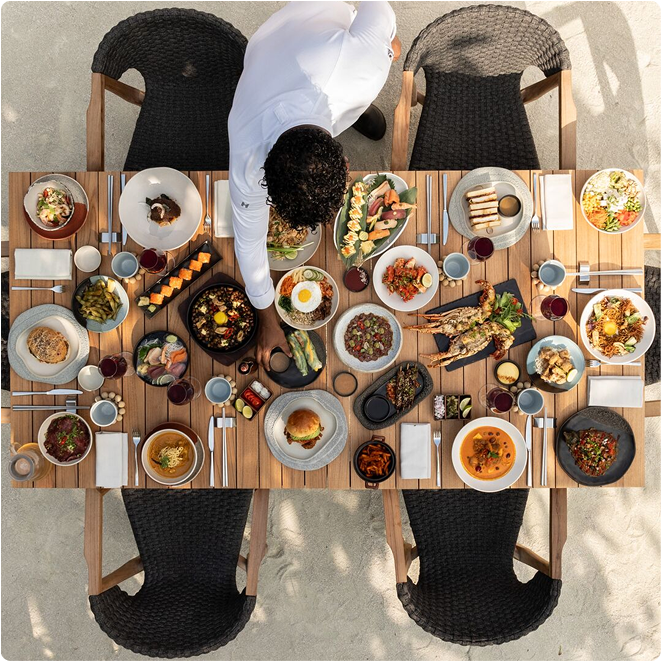 活気あるリゾートの食事を載せたテーブルを整える人物。