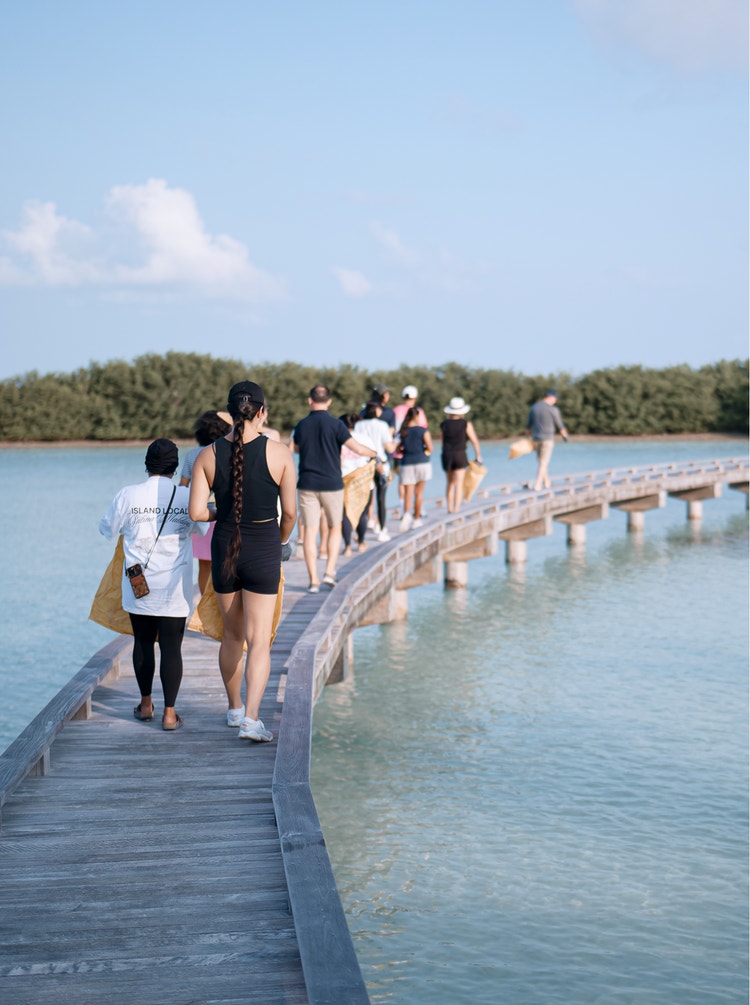 Group walks pier with cleanup bags