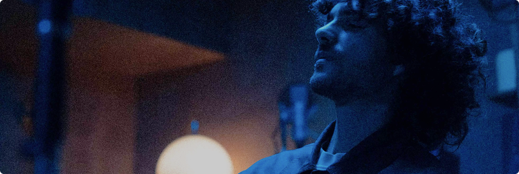 Artist in contemplative blue-lit space