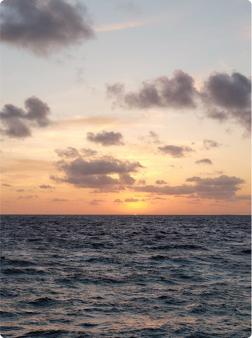远方落日映照海面，景色如画。