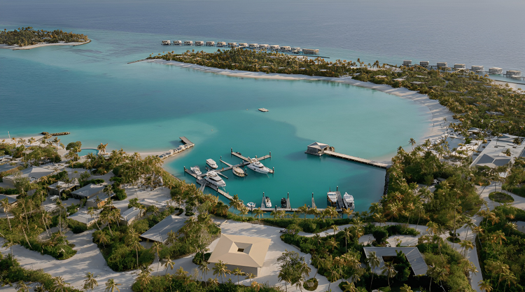 Aerial view of a tropical marina with turquoise waters, docked yachts, and lush resort villas.