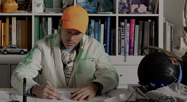 Daniel Arsham sketches at book-filled desk.