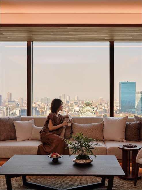 Guest gazes at Osaka castle skyline.