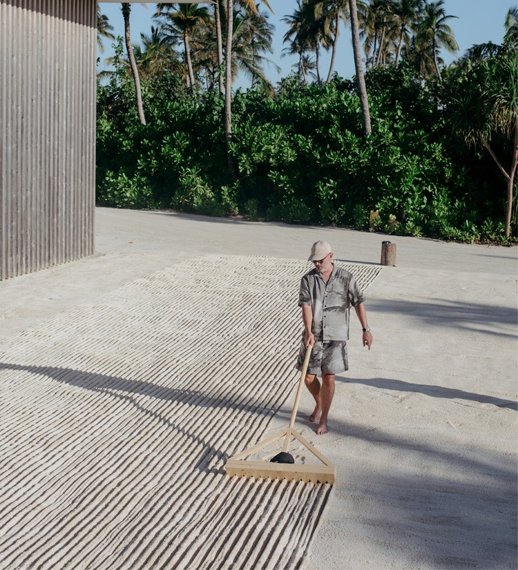 Person rakes sand into meditative lines.