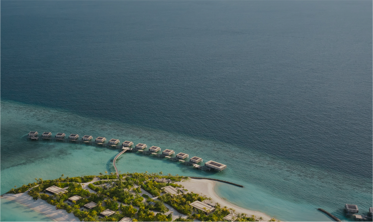 Overwater bungalows stretch into turquoise sea.