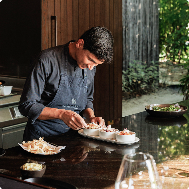 Chef garnishes dishes in resort kitchen