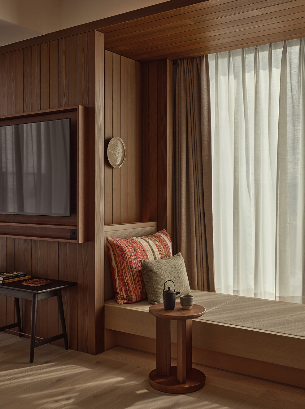 Cushioned nook beside wood-framed TV.