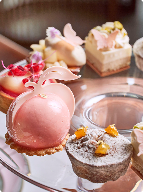 Pink dome pastry with floral garnish.