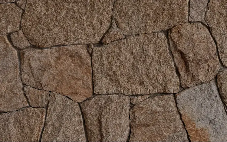 Irregular stone wall with rugged texture.