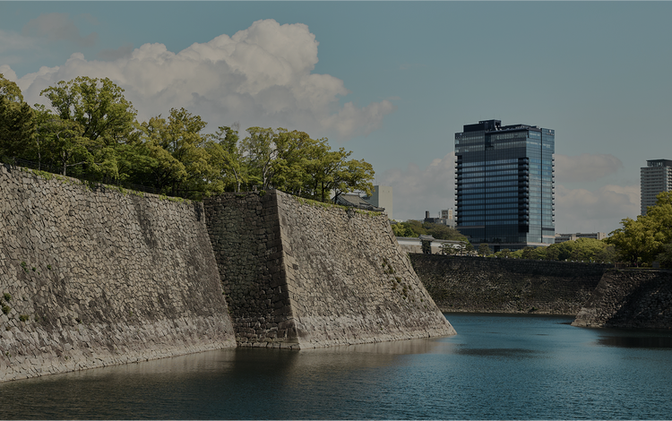 Stone wall meets glass high-rise skyline.