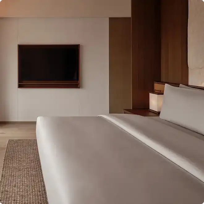 Neatly made bed with Italian Frette linen.