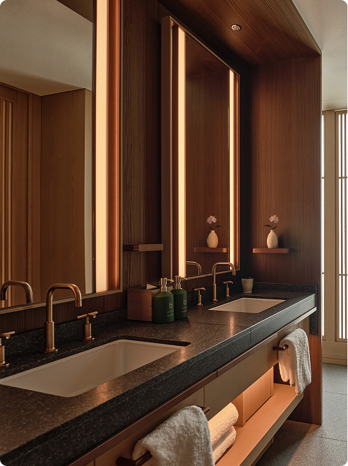 Twin sinks with warm ambient lighting.