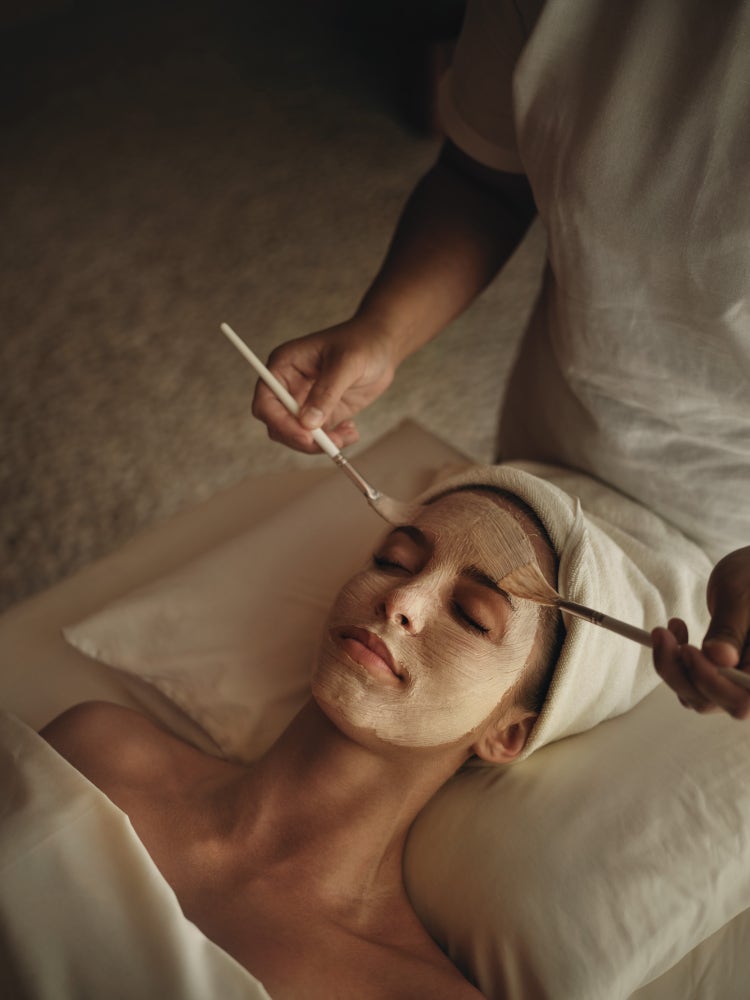 Spa therapist applies mask with brushes.